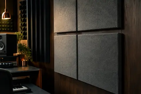 Panneaux acoustiques gris en fibres polyester installés au mur d’un home-studio avec mobilier en bois sombre.